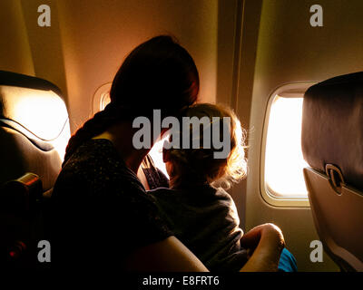 Madre e figlio guardando fuori della finestra di aeroplano Foto Stock