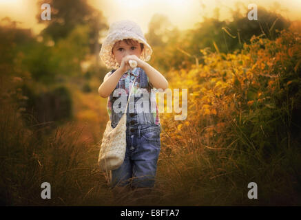 Ragazza in piedi in un prato giocando il registratore Foto Stock