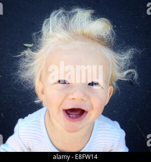 Ritratto di un ragazzo di ridere con capelli spazzate dal vento Foto Stock