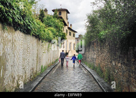 Padre e tre bambini camminando per strada, Firenze, Toscana, Italia Foto Stock