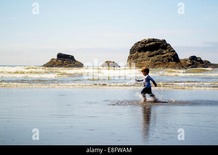 Ragazzo che corre sulla spiaggia nelle baraccie, Stati Uniti Foto Stock