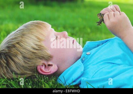 Ragazzo (4-5) guardando rana Foto Stock