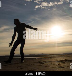 Uomo in piedi sulla spiaggia Foto Stock