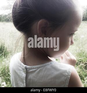 Vista posteriore di una ragazza in piedi nella luce solare Foto Stock