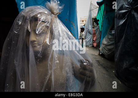 Un ONU-finito di dea Indù idolo di argilla è coperto con il foglio di plastica in Kumartoli, l'idolo makers town, in Kolkata,l'India Foto Stock