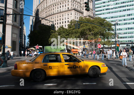 In Battery Park City, Manhattan, un taxi attende per i passeggeri. Alcuni New York City taxi portano pubblicità sui loro tetti. Vista di edifici e taxi in West Street / Hudson River Greenway dalla batteria Pl/ Battery Park, la parte inferiore di Manhattan, New York City. Foto Stock