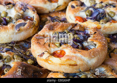 Focaccia pane artigianale, Italiano flatbread con erbe aromatiche, le olive e i pomodori. Foto Stock