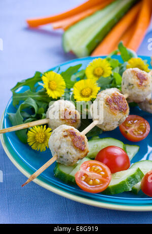 Le polpette di carne su spiedini con alcune verdure fresche sullo sfondo Foto Stock