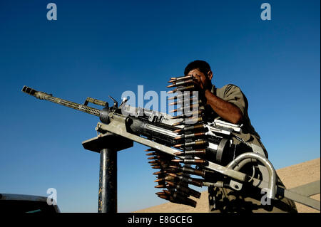 Un combattente curdo del popolo della Forze di Difesa HPG l ala militare del Partito dei Lavoratori del Kurdistan PKK proiettili di caricamento in una pesante DShK mitragliatrice montata su un open-backed civile carrello elevatore di prelievo Foto Stock