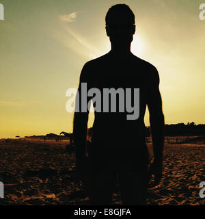 Silhouette di un uomo in piedi sulla spiaggia Foto Stock