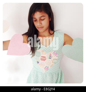 Ragazza che tiene un banner decorativo di San Valentino con forme di cuore Foto Stock