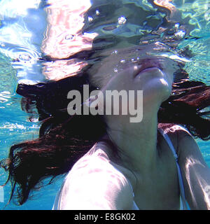 Primo piano di una donna in un abito che nuota sott'acqua, Sounion, Lavreotiki, Grecia Foto Stock