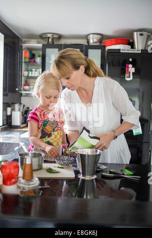 Madre e figlia nella preparazione degli alimenti in cucina Foto Stock