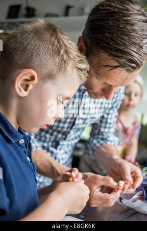 Padre e figlio gamberi di pulizia in cucina Foto Stock