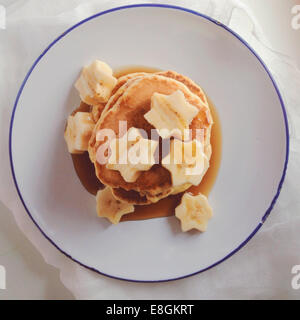 Pila di pancake con banana e sciroppo d'acero Foto Stock