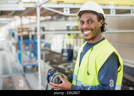 Ritratto di felice lavoratore sul sito in costruzione Foto Stock