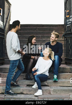 Multi etnico amici godendo sui passi Foto Stock