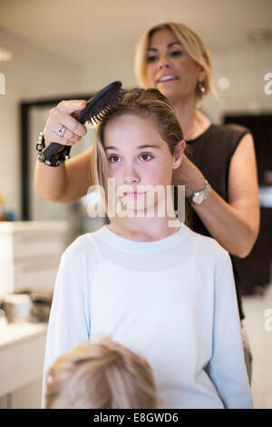 Madre figlia di pettinatura dei capelli a casa Foto Stock