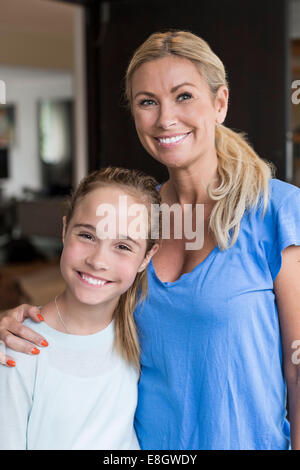 Ritratto di felice ragazza in piedi con la madre in piedi fuori casa Foto Stock