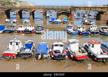 Lavoro barche da pesca spiaggiata a bassa marea in Folkestone Harbour. Foto Stock