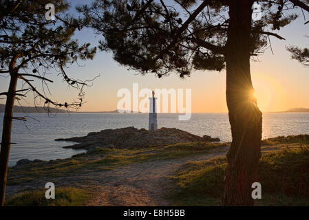 Spagna Galizia, Faro spiaggia di Leis de Nemancos al tramonto Foto Stock