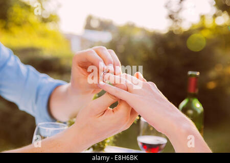 Uomo di mettere ad anello sulla donna del dito a cena Foto Stock