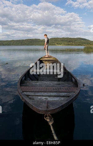 In Germania, in Renania Palatinato, Laach Lago, uomo in piedi sulla barca a remi Foto Stock