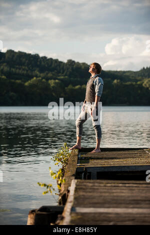 In Germania, in Renania Palatinato, Laach Lago, uomo in piedi sulla passerella di legno Foto Stock