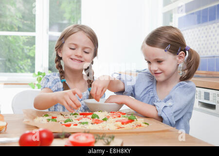 Germania - Monaco, ragazze (4-7) preparare il cibo in cucina Foto Stock