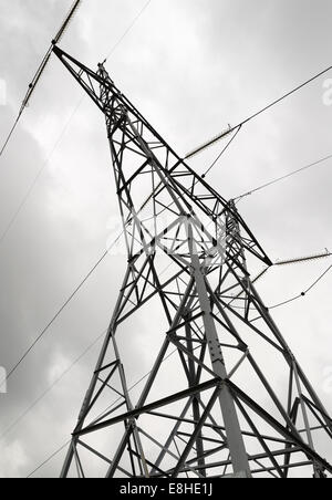 Le linee di alimentazione e di pilone elettrico contro il cielo nuvoloso Foto Stock