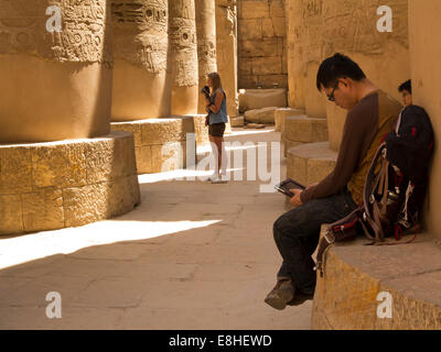 Egitto Luxor Tempio di Karnak, turisti in ombra tra le colonne di grande Hypostyle Hall Foto Stock