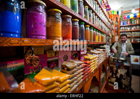Ritratto orizzontale di un proprietario di un negozio di spezie di pesatura nel souk di Marrakech. Foto Stock