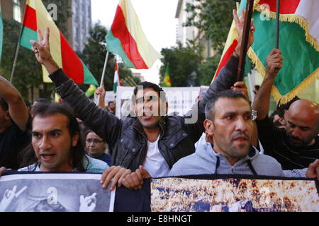 Atene, Grecia. 8 ottobre 2014. Un manifestante curdo grida slogan e fa un segno di vittoria. Curdi che vivono in Grecia hanno protestato contro gli attacchi di uno Stato islamico (SI) sulla città di Kobane in Siria, chiedono il sostegno internazionale dei combattenti curdi. Essi inoltre hanno protestato contro il presunto sostegno di è dallo stato turco. Credito: Michael Debets/Alamy Live News Foto Stock