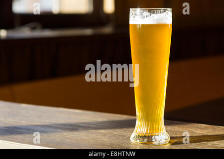 Bicchiere di birra in Sunray sul tavolo Foto Stock