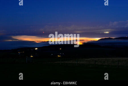 Forres, murene, Scozia, 8 ottobre, 2014. Cacciatori di luna che illuminava una nebbiosa Forres e al di sopra del Moray Firth a credito: Steve Arkley/Alamy Live News Foto Stock