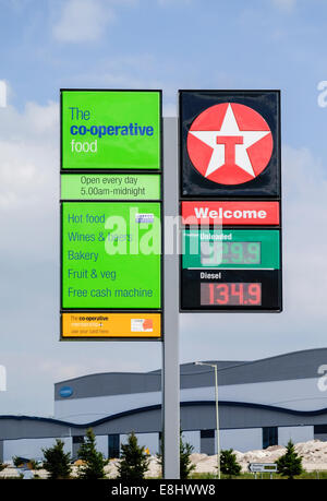 Co-operativa shop segno e Texaco stazione di benzina che mostra i prezzi del carburante, Wiltshire, Inghilterra, Regno Unito Foto Stock