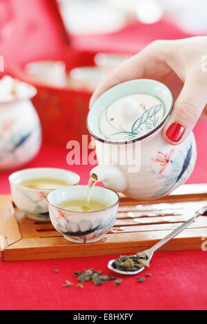 Versando il tè verde Foto Stock