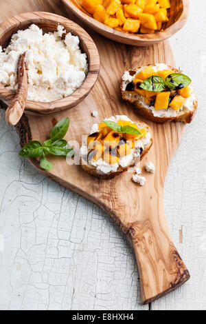 La bruschetta con un trito di mango, il basilico e il formaggio di capra su baguette fresca Foto Stock