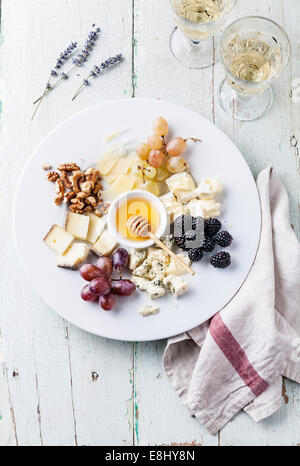 Il piatto di formaggi assortimento di vari tipi di formaggio e miele sulla piastra bianca Foto Stock