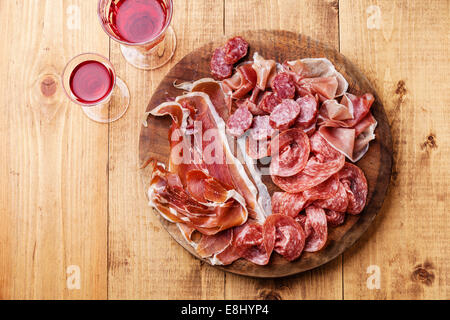 Carne fredda piastra e vino su sfondo di legno Foto Stock