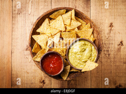 Fresco e salsa guacamole salse con nachos chips su sfondo di legno Foto Stock