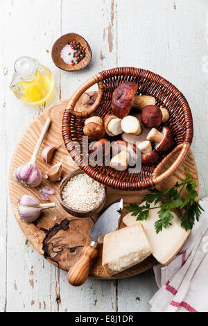 Ingredienti per il risotto con funghi selvatici su sfondo di legno Foto Stock