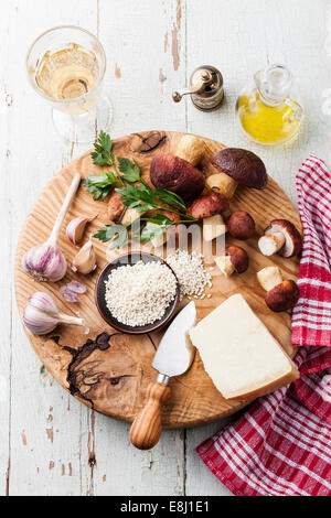 Ingredienti per il risotto con funghi selvatici su sfondo di legno Foto Stock