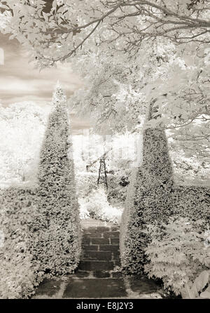 Fotografia a infrarossi di un classico giardino inglese, la casella piramidi gateway di formatura a Wollerton Old Hall (NGS) Market Drayton nel Shro Foto Stock