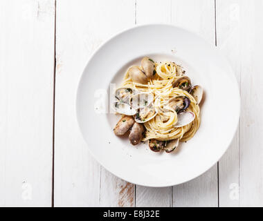 Piatti di pasta con le vongole Spaghetti alle Vongole in bianco sullo sfondo di legno Foto Stock