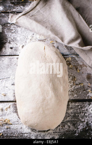 La cottura del pane. La pasta su un tavolo di legno con la farina. Vista dall'alto. Foto Stock