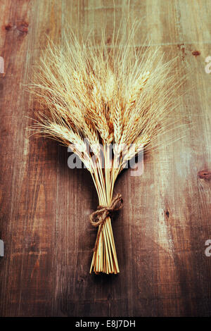 Spighe di grano su sfondo di legno Foto Stock