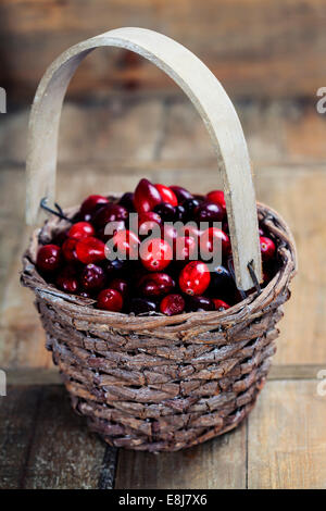 Ripe rosso di mirtilli rossi cesto su sfondo di legno Foto Stock