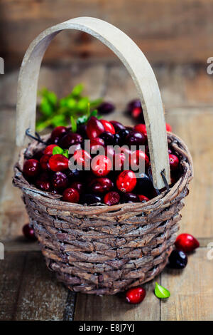 Ripe rosso di mirtilli rossi cesto su sfondo di legno Foto Stock