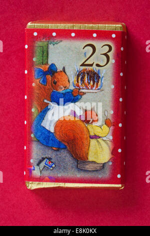 Il conto alla rovescia per il Natale con i singoli avvento barrette di cioccolato isolato su sfondo rosso - giorno di calendario 23 del set di 24 Foto Stock